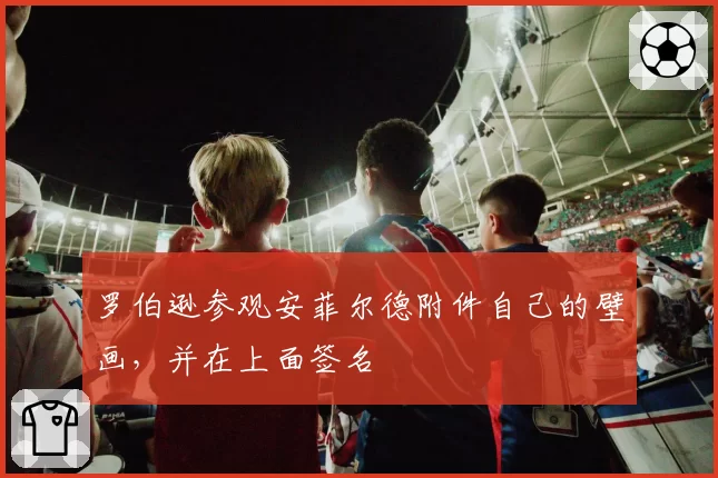 罗伯逊参观安菲尔德附件自己的壁画，并在上面签名